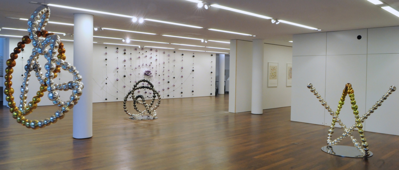 Nœud ambre dégradé miroir, 2012 (left). Mirrored glass, stainless steel. The Knot of the Real, 2012 (center). Black and grey mirrored glass, stainless steel. Nœud vert et ambre, 2012 (right). Green and amber mirrored glass, stainless steel.